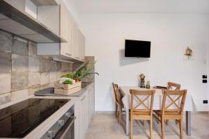 a kitchen with a table and chairs and a tv at Antichi Ricordi - Da Angela in Marina di Andora