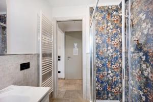 a bathroom with a shower with a blue floral wallpaper at Antichi Ricordi - Da Angela in Marina di Andora +10 photos