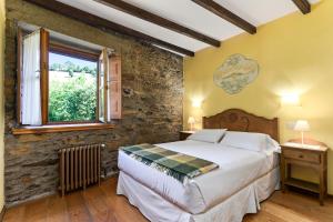 a bedroom with a bed and a window at Casa Rural Casa Mario in Cangas del Narcea