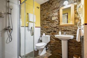 a bathroom with a toilet and a sink at Casa Rural Casa Mario in Cangas del Narcea +19 photos