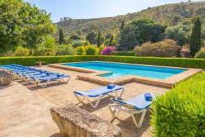 a swimming pool with two lounge chairs and a poolvisorvisorvisor at Can Faveta in Alcudia