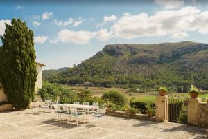 a patio with a table and chairs in front of a mountain at Can Faveta in Alcudia
