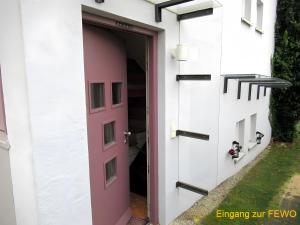 a pink door into a white house with a pink entrance at Ferienwohnung Stine in Stetten +19 photos