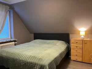 a bedroom with a bed and a dresser and a window at Wohnung mit Fernblick in Jübek