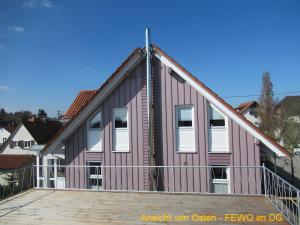 a house with a gambrel roof on a deck at Ferienwohnung Stine in Stetten