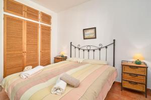 a bedroom with a large bed with two towels at Carabeo 19 in Nerja +25 photos