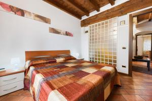 a bedroom with a bed and a tiled wall at Casa Laura in Salò