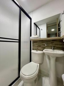 ein Badezimmer mit Toilette und Waschbecken in der Unterkunft Hotel Adel in Manizales