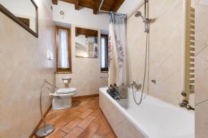 a bathroom with a tub and a toilet and a shower at Casa Laura in Salò +18 photos