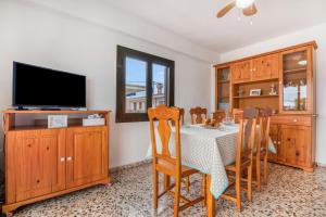 a dining room with a table and a flat screen tv at Manhattan in Oliva