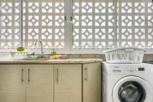 a kitchen with a washing machine and a window at Manhattan in Oliva