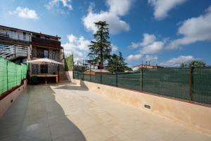 a tennis court with a fence and a tree at Villa Marzla in Cassano delle Murge