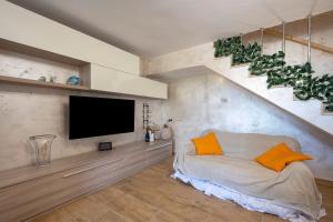 a living room with a tv and a couch with orange pillows at Villa Marzla in Cassano delle Murge