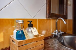 a wooden box with two bottles of soap and a sink at Casa Florenta G4 in Cangas de Onís