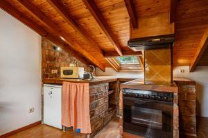 a kitchen with wooden ceilings and a stove top oven at Casa Florenta G4 in Cangas de Onís +14 photos