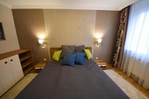 - une chambre dotée d'un grand lit avec des oreillers bleus et jaunes dans l'établissement Rosehill Side Apartment, à Budapest