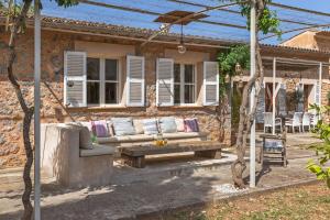a patio with a couch and a table in front of a house at Finca Can Nou in Sóller