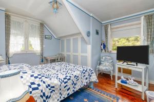 a bedroom with a bed and a flat screen tv at La Renardière - Chambre in Férel