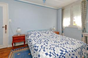 a blue bedroom with a bed and a table with a night stand at La Renardière - Chambre in Férel