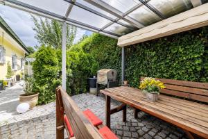 a patio with a wooden bench and an umbrella at Haus Fabio in Großengstingen
