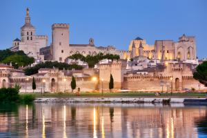 a view of a castle from the water at night at Chambres D'hôtes La Buissonnière in Théziers