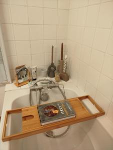 a book sitting on top of a bath tub at Chambres D'hôtes La Buissonnière in Théziers