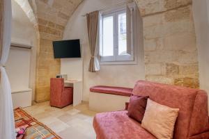 ein Wohnzimmer mit Sofa und Fenster in der Unterkunft Antony Suite Strada in Lecce