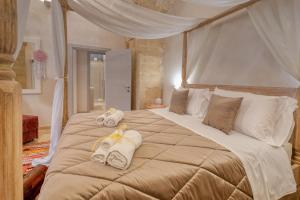 ein Schlafzimmer mit einem großen Bett, auf dem Handtücher liegen in der Unterkunft Antony Suite Strada in Lecce