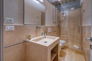 ein Badezimmer mit Waschbecken, Dusche und Toilette in der Unterkunft Antony Suite Strada in Lecce + 16 Fotos