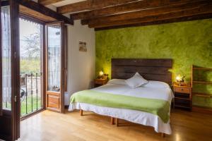 a bedroom with a bed with a green wall at Zadorra Etxea Casa in Salvatierra