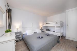 a white bedroom with a large bed with two pillows at Can Botana 1 in Cala de Sant Vicenc +21 photos