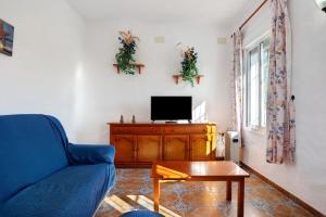 a living room with a blue couch and a tv at Las Calas de Roche in Roche