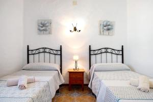 a bedroom with two beds and a table with a lamp at Las Calas de Roche in Roche