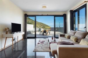 a living room with a couch and a tv at Casa da Pontinha in Machico