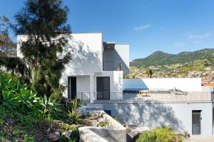 a white house with a black roof at Casa da Pontinha in Machico