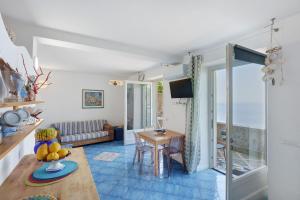 a living room with a table and a couch at Casa Il Geco Praiano in Praiano