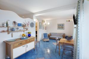 a kitchen and living room with a table and a couch at Casa Il Geco Praiano in Praiano