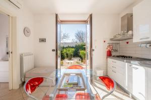a kitchen with a glass table and red chairs at Villa Olga in Nardò