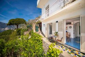 a house with a balcony with a view of the mountains at Casa Il Geco Praiano in Praiano