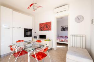 a dining room with a glass table and red chairs at Villa Olga in Nardò