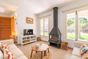 a living room with a fireplace and a stove at Can Botana 12 in Cala de Sant Vicenc