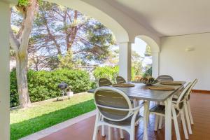a dining room with a table and chairs on a patio at Can Botana 12 in Cala de Sant Vicenc