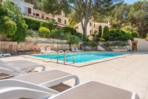 a swimming pool with lounge chairs next to a building at Can Botana 12 in Cala de Sant Vicenc