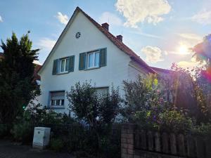 a white house with a fence in front of it at s'Krumme Gustels Hüs in Bahlingen