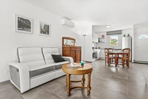 a living room with a couch and a table at Villa les Coteaux du soleil in Carcès