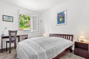 a bedroom with a bed and a desk and a window at Villa les Coteaux du soleil in Carcès +14 photos