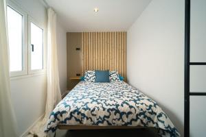 a bedroom with a bed with a blue and white comforter at Kay lava in Famara