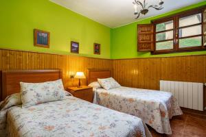 ein Schlafzimmer mit zwei Betten und grünen Wänden in der Unterkunft Socastillo B in Bárzana