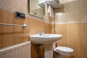 ein Badezimmer mit Waschbecken, Toilette und Spiegel in der Unterkunft Socastillo B in Bárzana + 15 Fotos