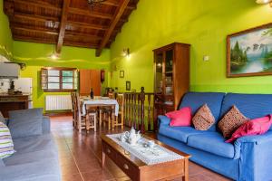 ein Wohnzimmer mit einem blauen Sofa und einem Tisch in der Unterkunft Socastillo B in Bárzana